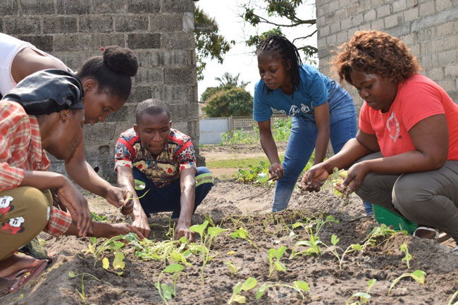 Deaf project beneficiaries learning to transplant seedlings in a newly dug bed (credit: bold impact africa)